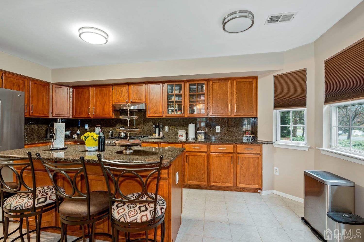 58 Nova Drive Piscataway, NJ 08854 - Photo 8 of 16 a kitchen with stainless steel appliances granite countertop a stove top oven a sink a dining table and chairs