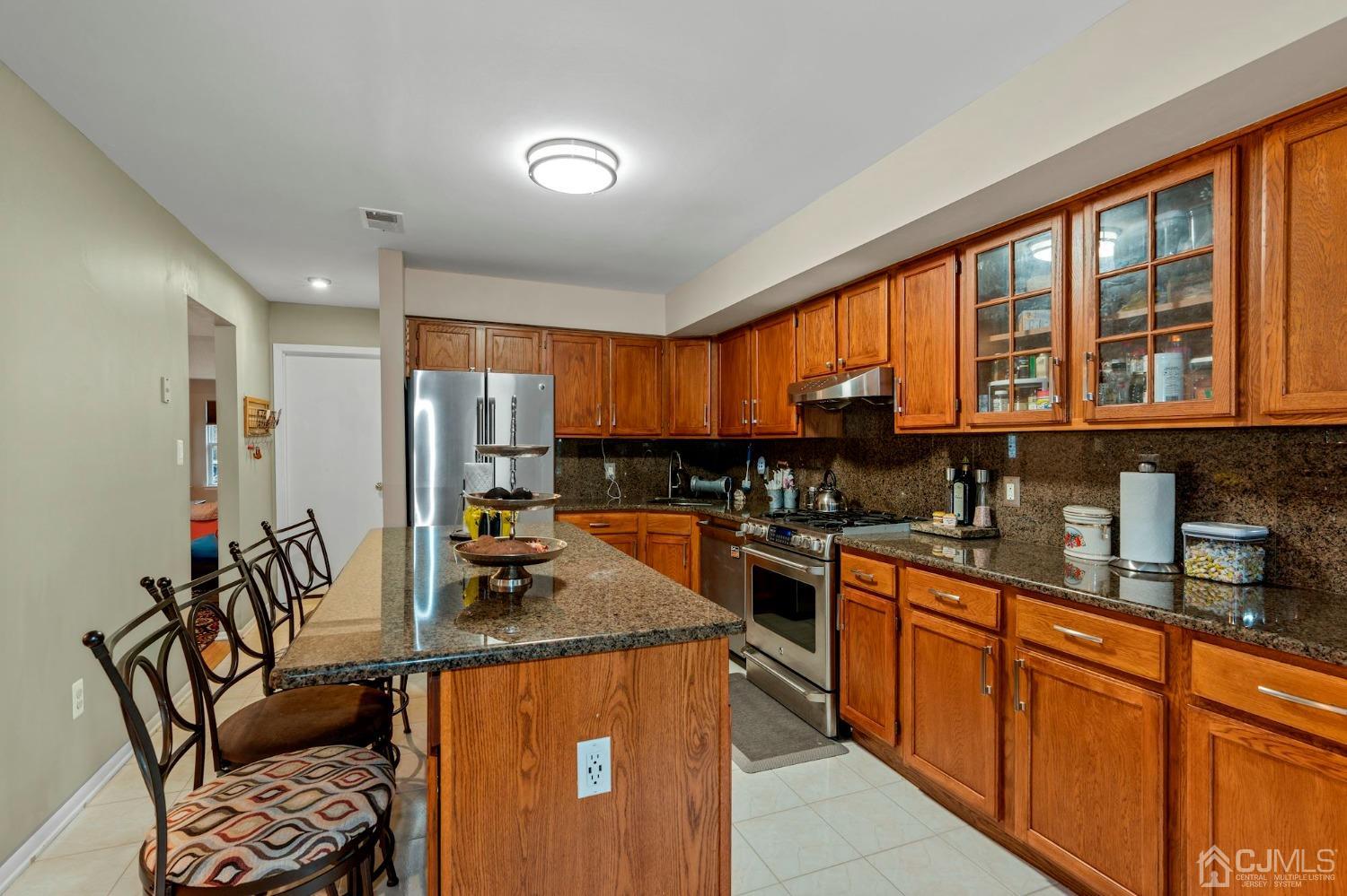 58 Nova Drive Piscataway, NJ 08854 - Photo 9 of 16 a kitchen with stainless steel appliances granite countertop sink stove top oven and cabinets