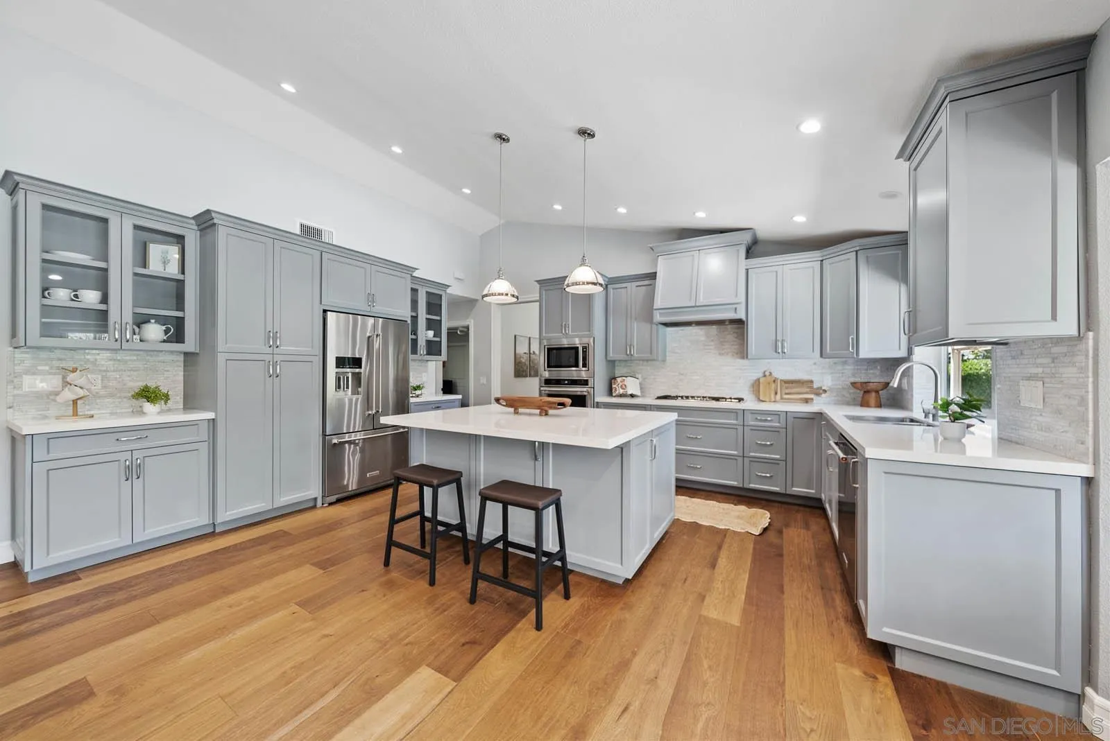14012 Valley Springs Road Poway, CA 92064 - Photo 17 of 57 a kitchen with white cabinets and stainless steel appliances