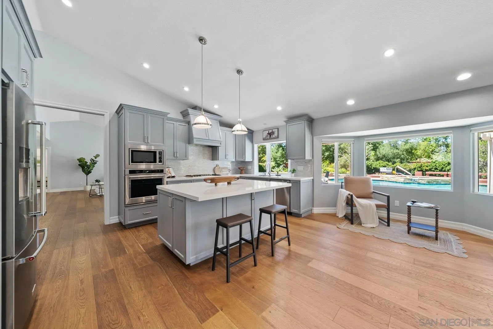14012 Valley Springs Road Poway, CA 92064 - Photo 18 of 57 a kitchen with stainless steel appliances kitchen island hardwood floor sink stove table and chairs