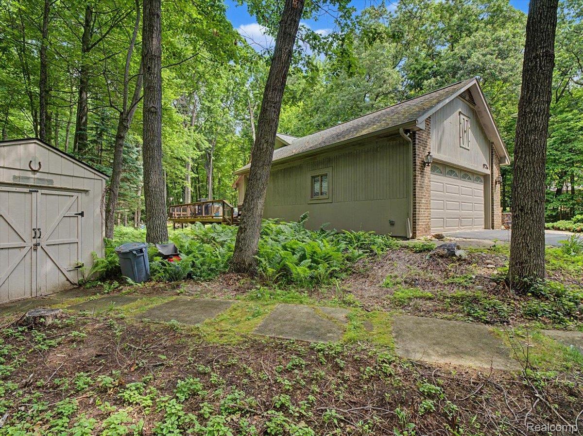 9714 Naiad Road Clarkston, MI 48348 - Photo 6 of 61 On the garage side of the home, a storage shed sits conveniently along a cement-padded path, offering easy access and additional space for tools, equipment, or seasonal items.
