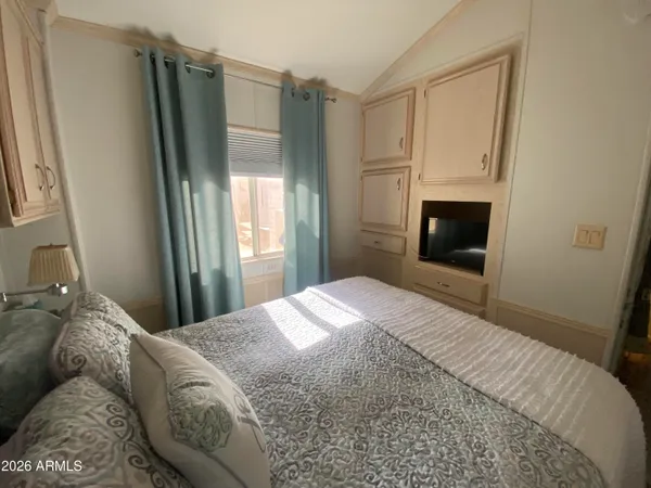 a bedroom with a bed and a refrigerator
