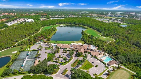 an aerial view of residential houses with outdoor space and trees