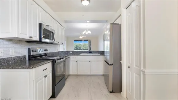 a kitchen with stainless steel appliances granite countertop a stove a sink and a refrigerator