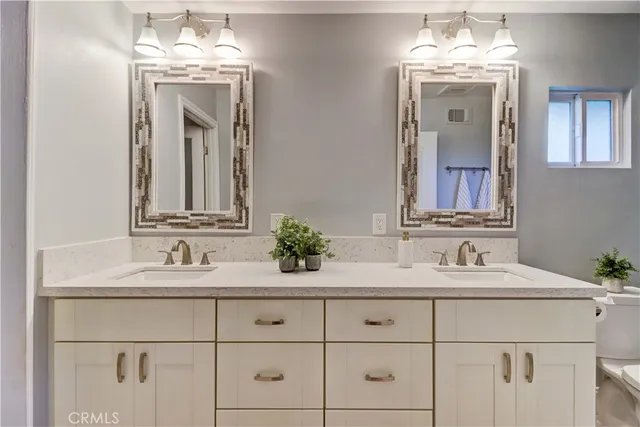 a bathroom with double vanity sinks and a mirror