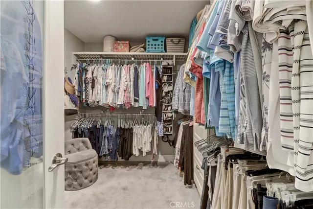 a view of walk in closet with clothes