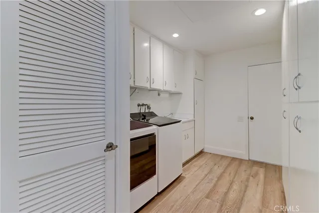 a kitchen with granite countertop white cabinets and white appliances