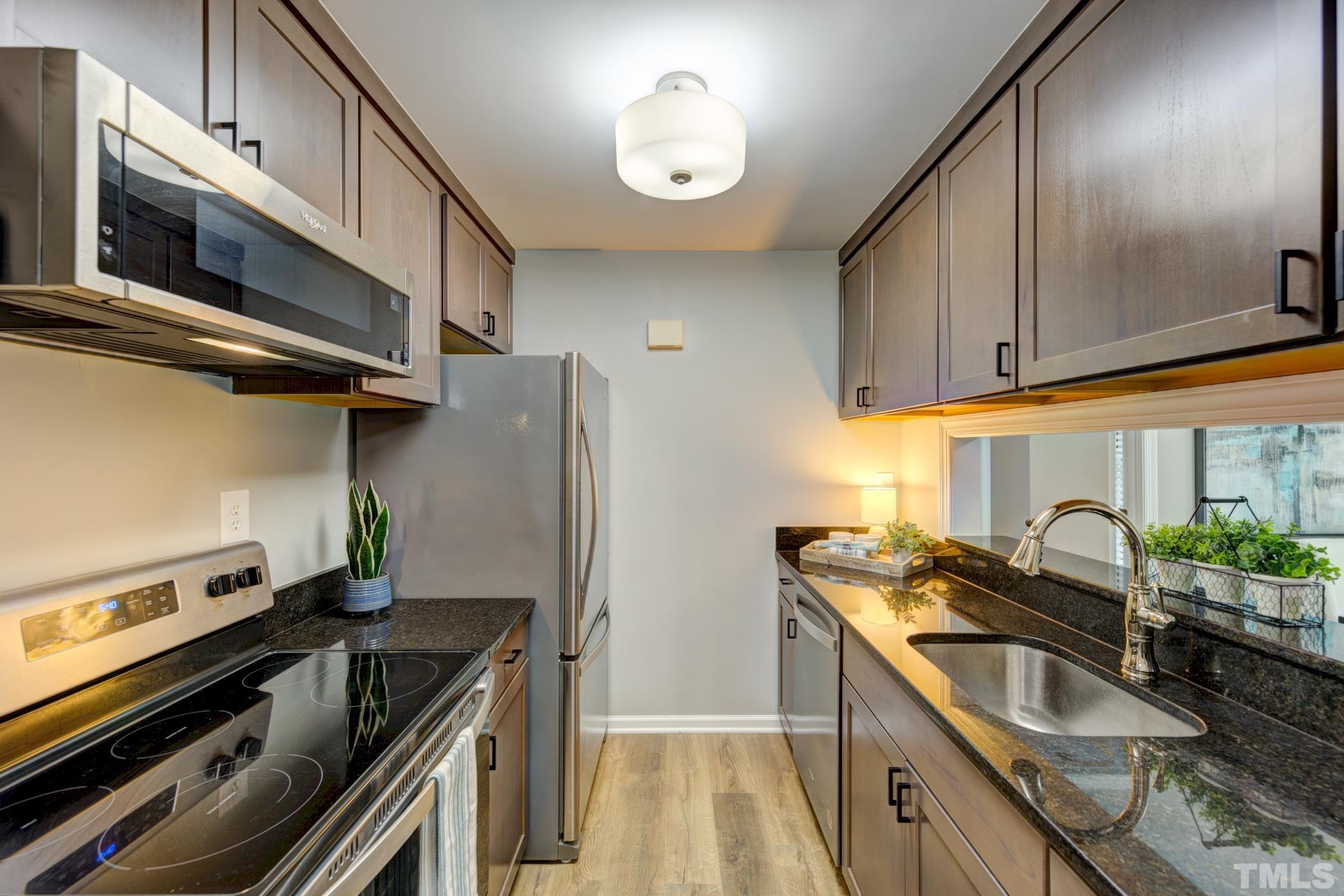 3623 Mill Run, Unit 3623 Raleigh, NC 27612 - Photo 8 of 23 a kitchen with granite countertop a sink stainless steel appliances and cabinets