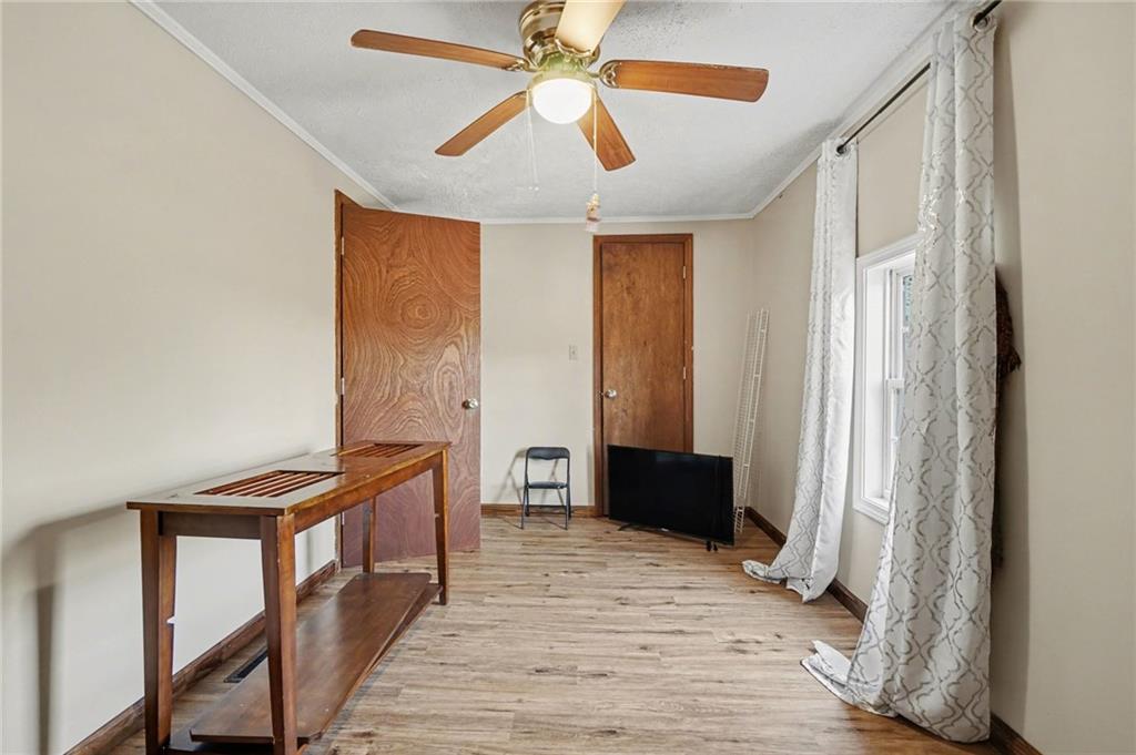 2986 Defore Road Toccoa, GA 30577 - Photo 12 of 19 a view of a hallway to a livingroom with wooden floor and a ceiling fan