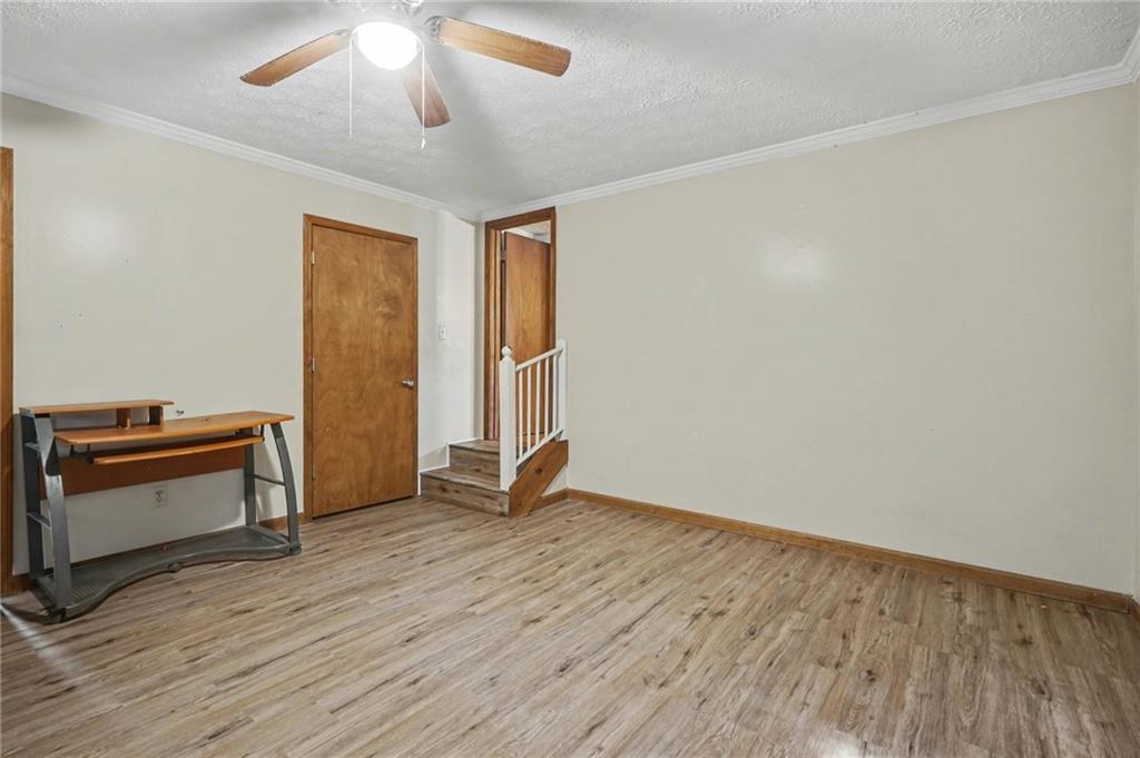 2986 Defore Road Toccoa, GA 30577 - Photo 8 of 19 an empty room with wooden floor a ceiling fan and windows