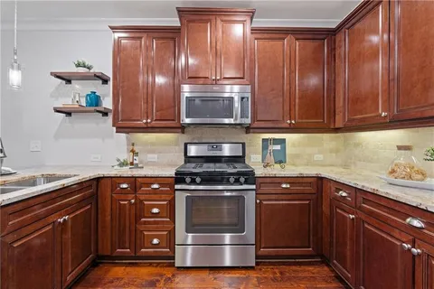 a kitchen with granite countertop wooden cabinets and stainless steel appliances