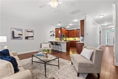 a living room with furniture kitchen view and a chandelier
