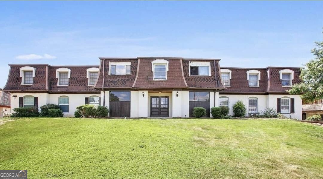 a brick house that has a lots of windows in it