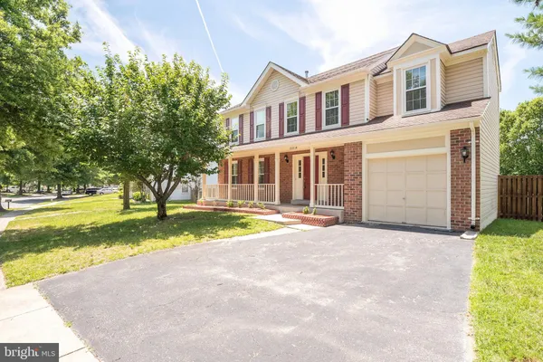 a view of yellow house with a swimming pool and a yard