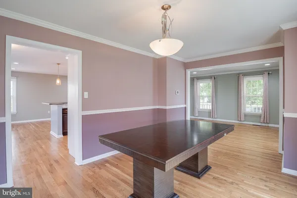 a kitchen with stainless steel appliances granite countertop a refrigerator a sink dishwasher a stove and white cabinets with wooden floor