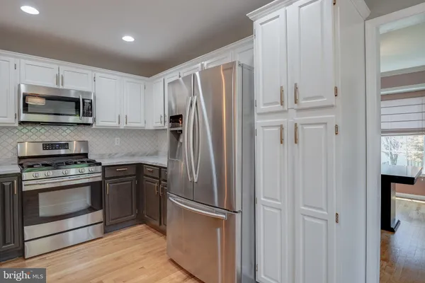 a metallic refrigerator freezer sitting in a kitchen