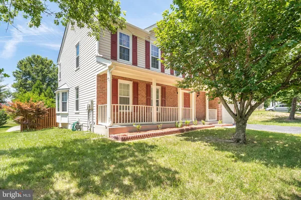a front view of a house with a yard and trees