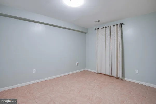 an empty room with windows and fireplace