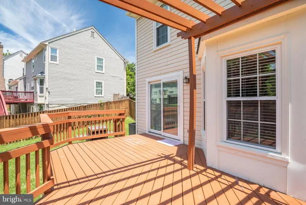 a view of a house with a yard porch and wooden fence
