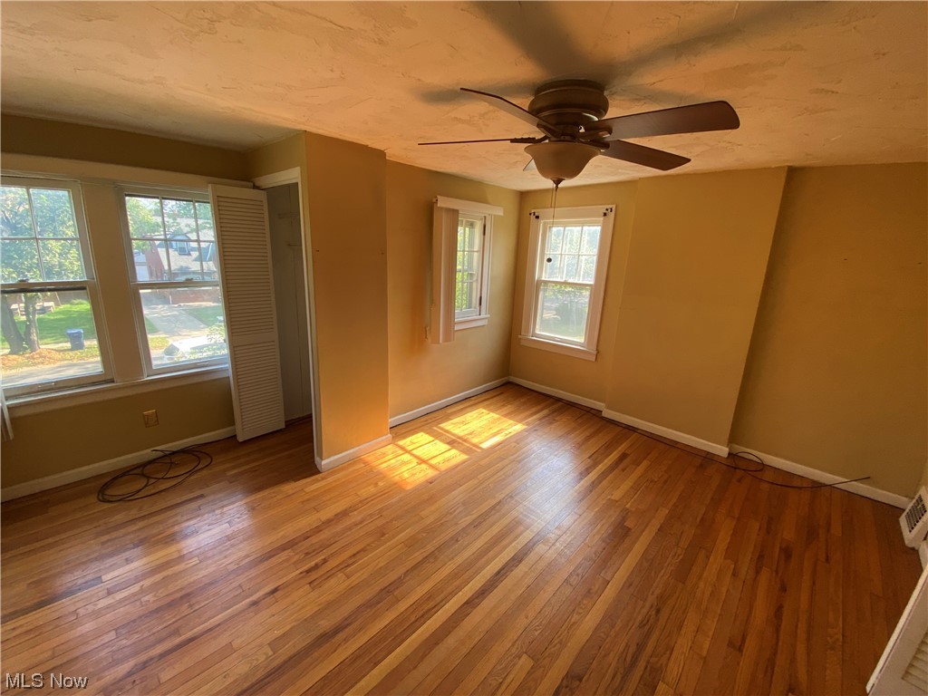 3630 Bainbridge Road Cleveland Heights, OH 44118 - Photo 11 of 21 Empty room with a wealth of natural light, ceiling fan, and light hardwood / wood-style floors