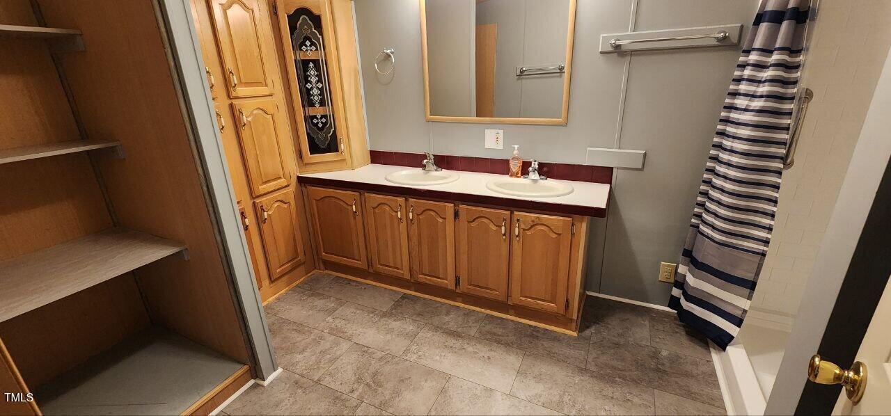 4470 Thomas Road Henderson, NC 27537 - Photo 13 of 21 a bathroom with a sink and a mirror