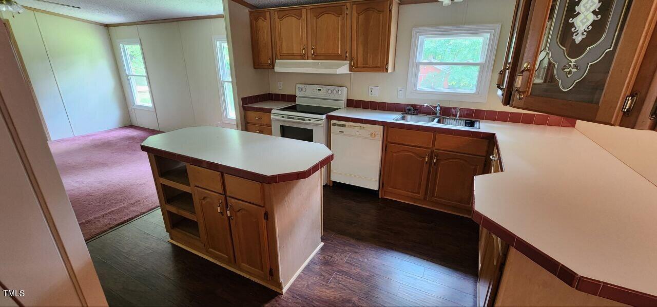 4470 Thomas Road Henderson, NC 27537 - Photo 10 of 21 a kitchen with stainless steel appliances granite countertop a sink stove and a refrigerator