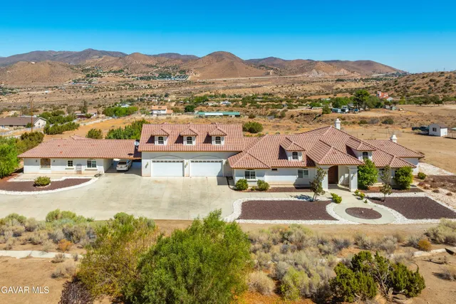 a view of a dry yard with mountains in the background