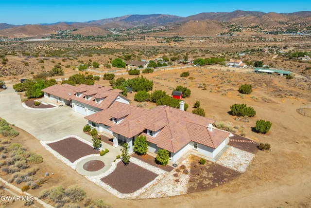 a view of a grey house with large windows