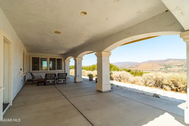 a view of a dry yard with mountains in the background