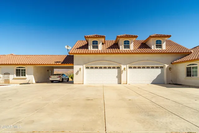 a view of a workspace with furniture and a book shelf