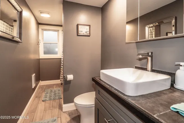 a bathroom with a sink a toilet and mirror