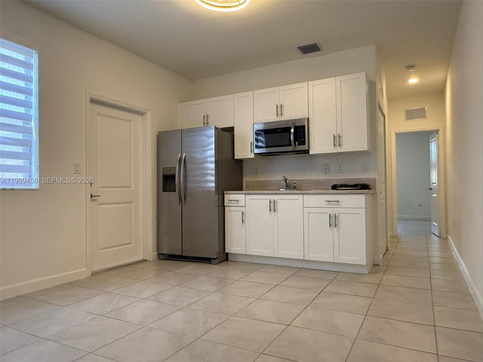 11909 Southwest 244th Street, Unit EFFICIENCY Homestead, FL 33032 - Photo 3 of 11 a kitchen with a refrigerator sink and microwave