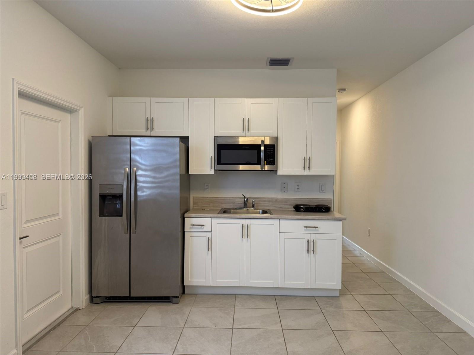 11909 Southwest 244th Street, Unit EFFICIENCY Homestead, FL 33032 - Photo 4 of 11 a kitchen with stainless steel appliances granite countertop a refrigerator and a stove