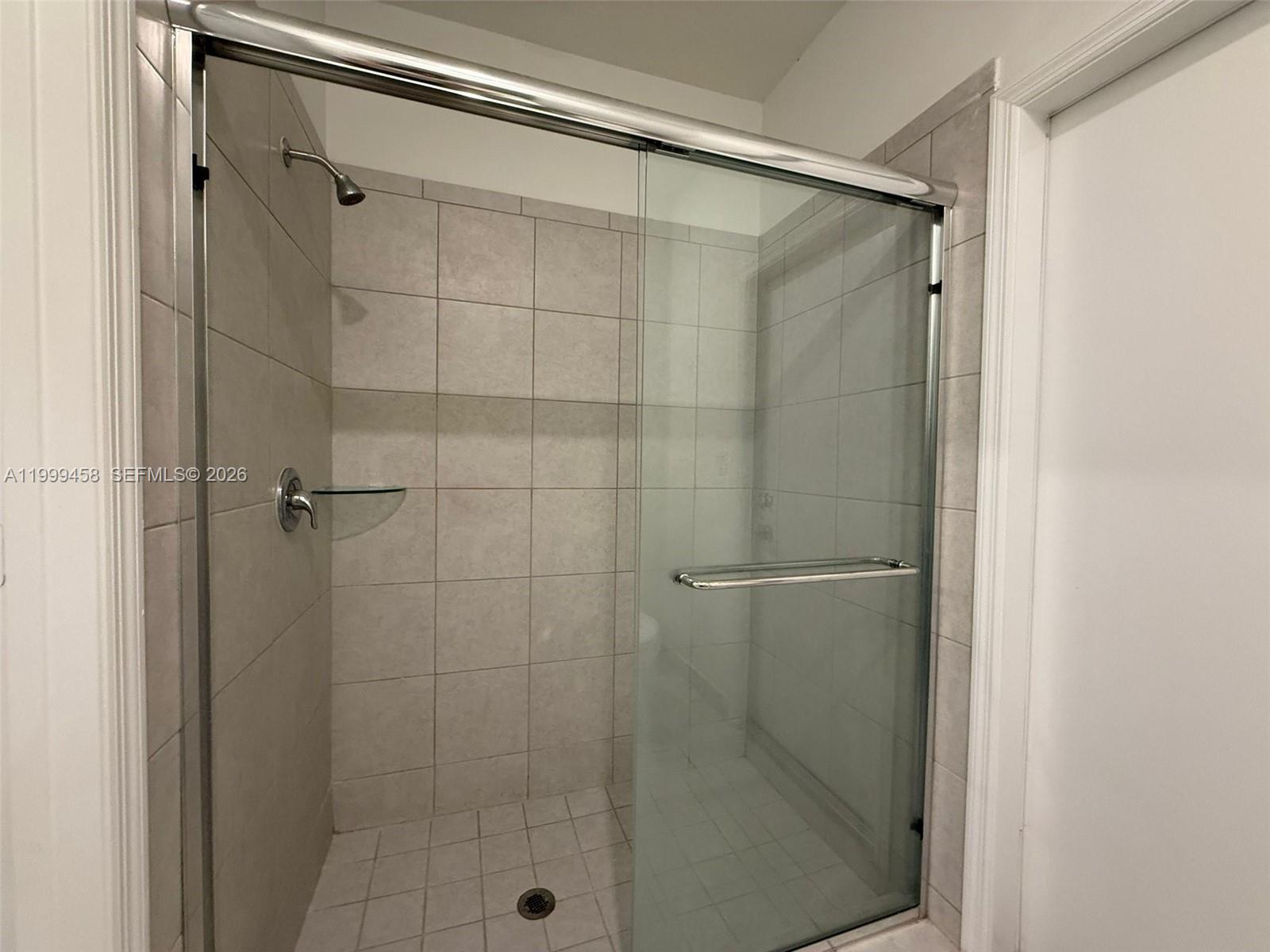 11909 Southwest 244th Street, Unit EFFICIENCY Homestead, FL 33032 - Photo 7 of 11 a bathroom with a glass shower door