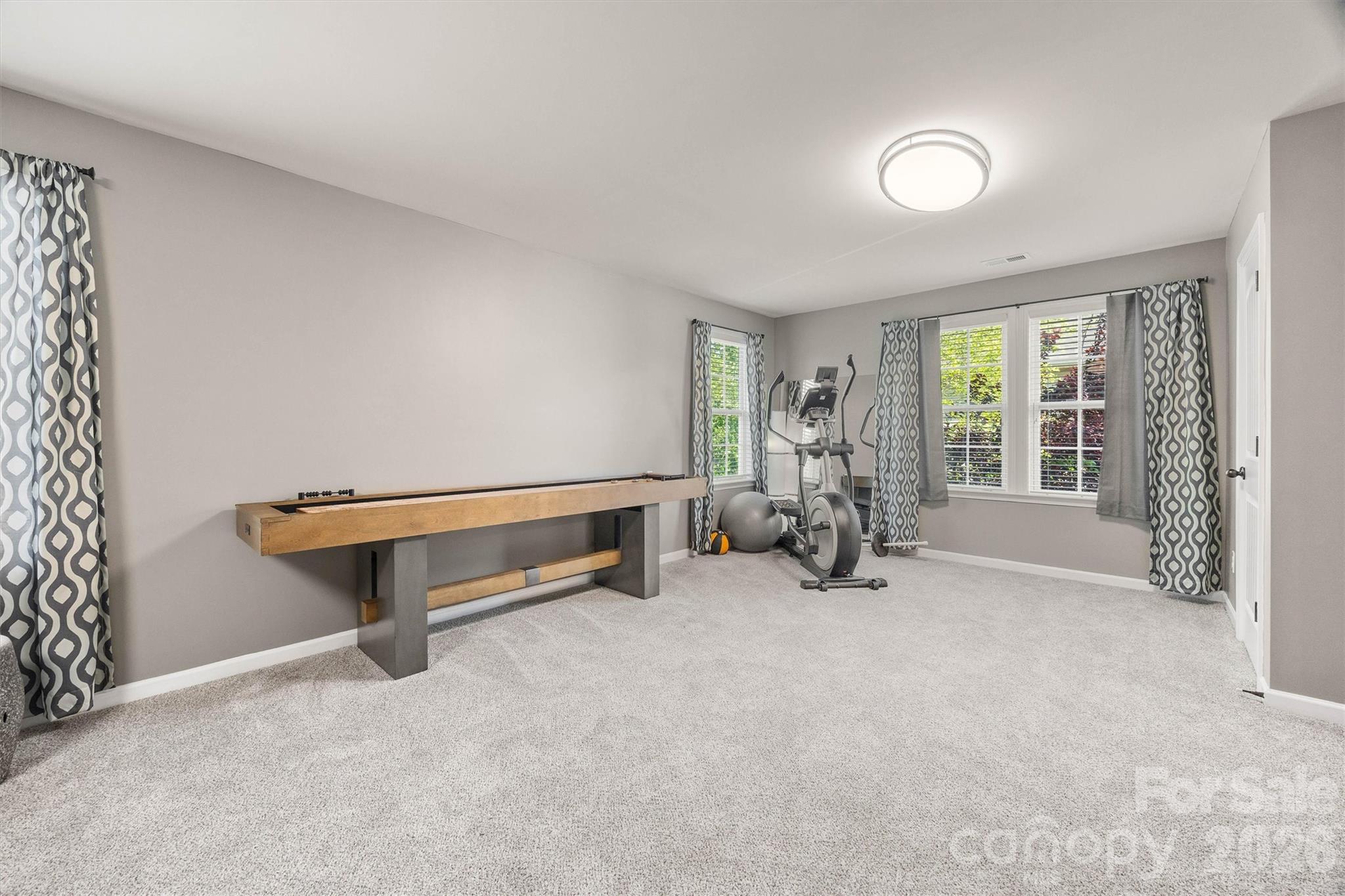 299 Annatto Way Tega Cay, SC 29708 - Photo 37 of 46 a living room with furniture gym equipment and large windows