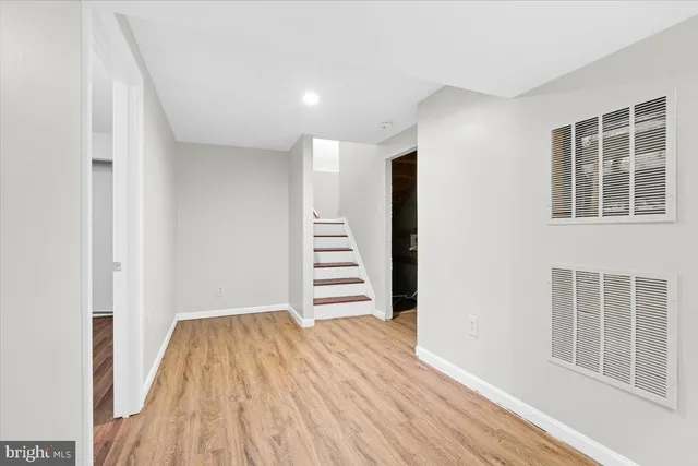 a view of room with stairs and wooden floor