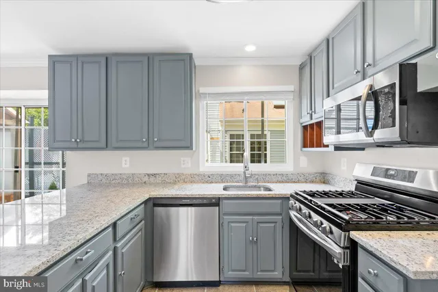 a kitchen with granite countertop a sink stove and cabinets