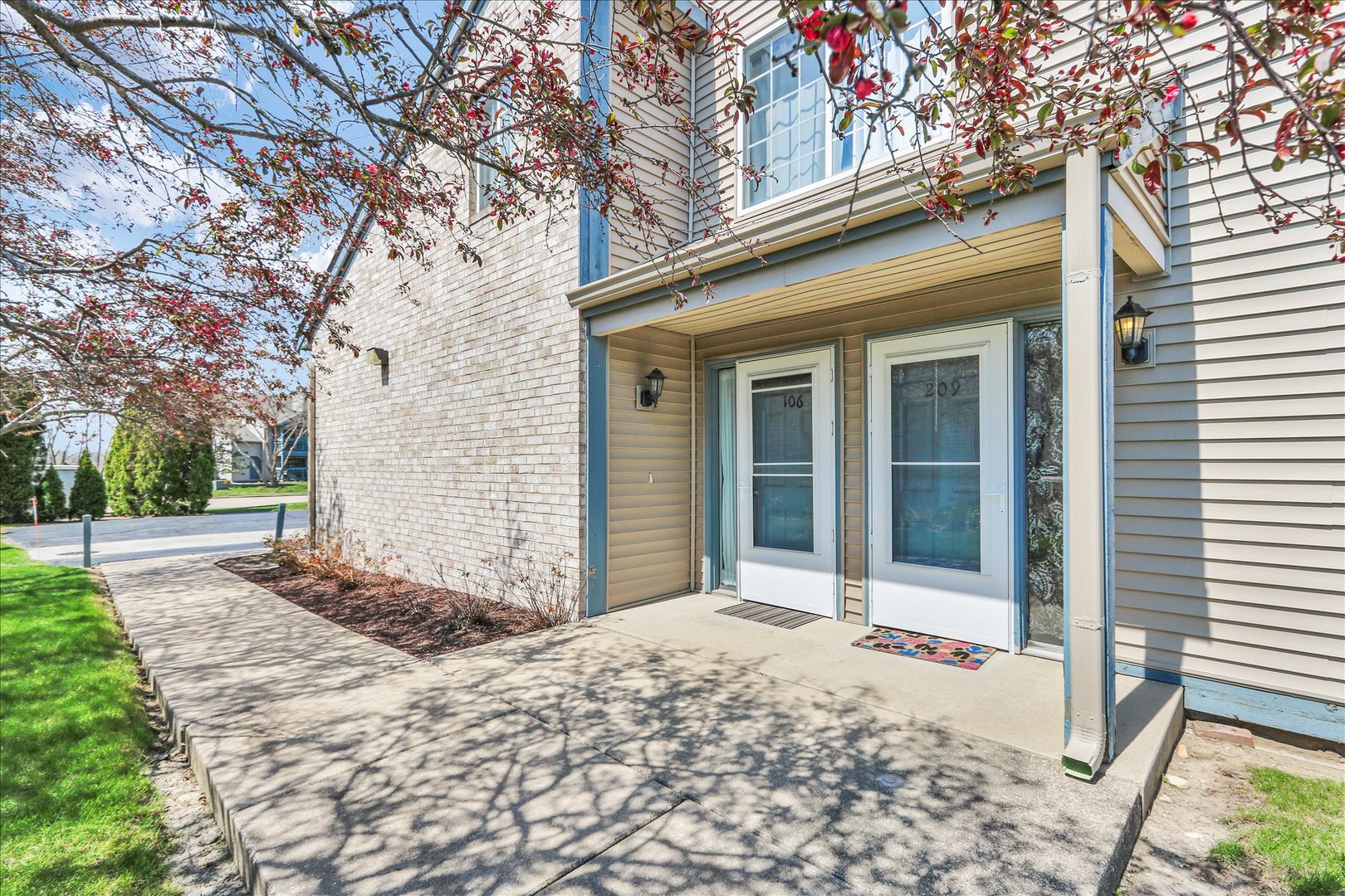 2402 Windward Boulevard, Unit 209 Champaign, IL 61821 - Photo 3 of 33 a backyard of a house with large tree and wooden fence