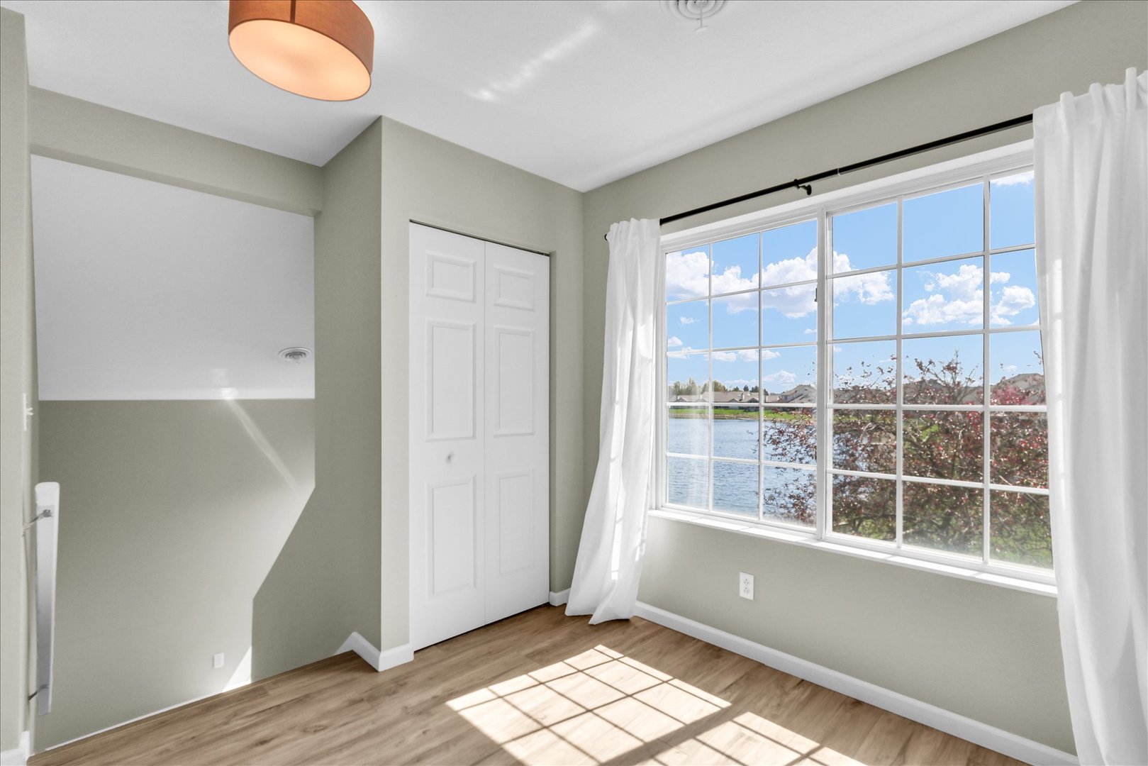 2402 Windward Boulevard, Unit 209 Champaign, IL 61821 - Photo 9 of 33 an empty room with wooden floor and windows