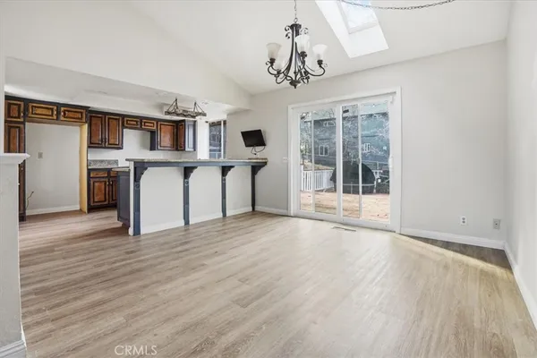 a kitchen that has a microwave a stove and a table with wooden floor