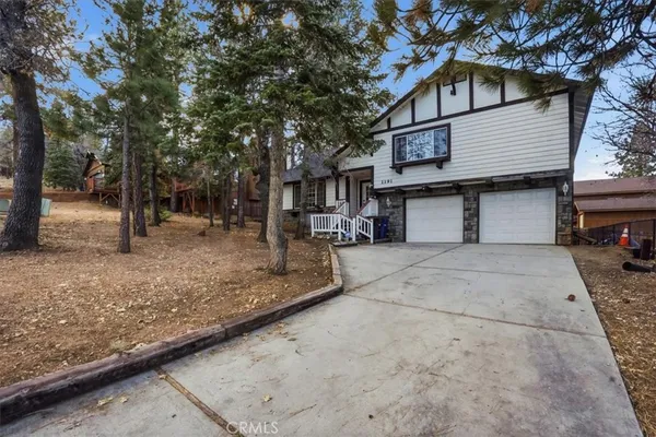 a view of a house with a tree in the background