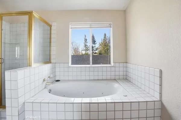 a view of a brick house with large trees and wooden fence