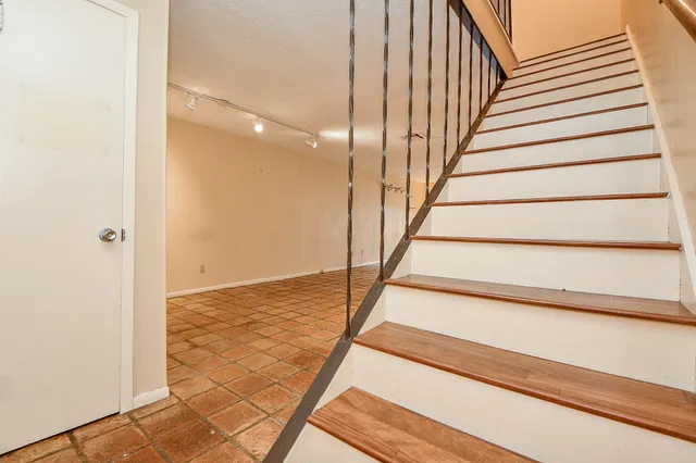 a bathroom with a granite countertop toilet a sink and a mirror