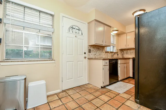 a kitchen with granite countertop a refrigerator and a sink