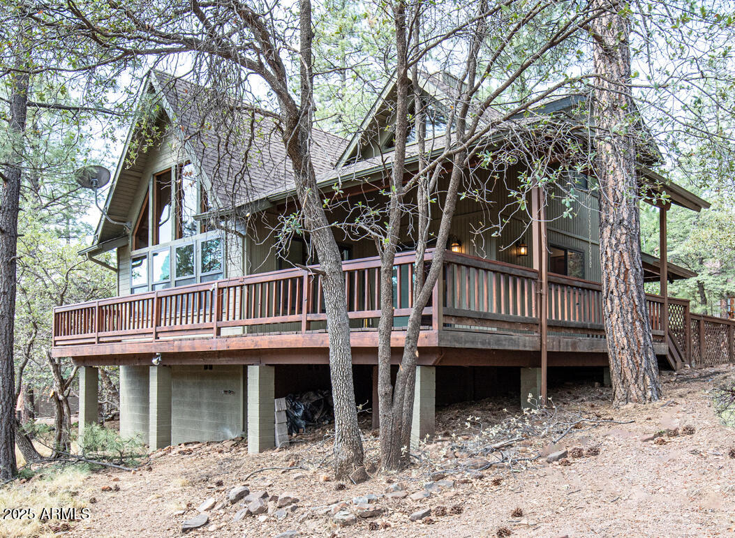 a view of a house with a balcony wooden fence and a tree