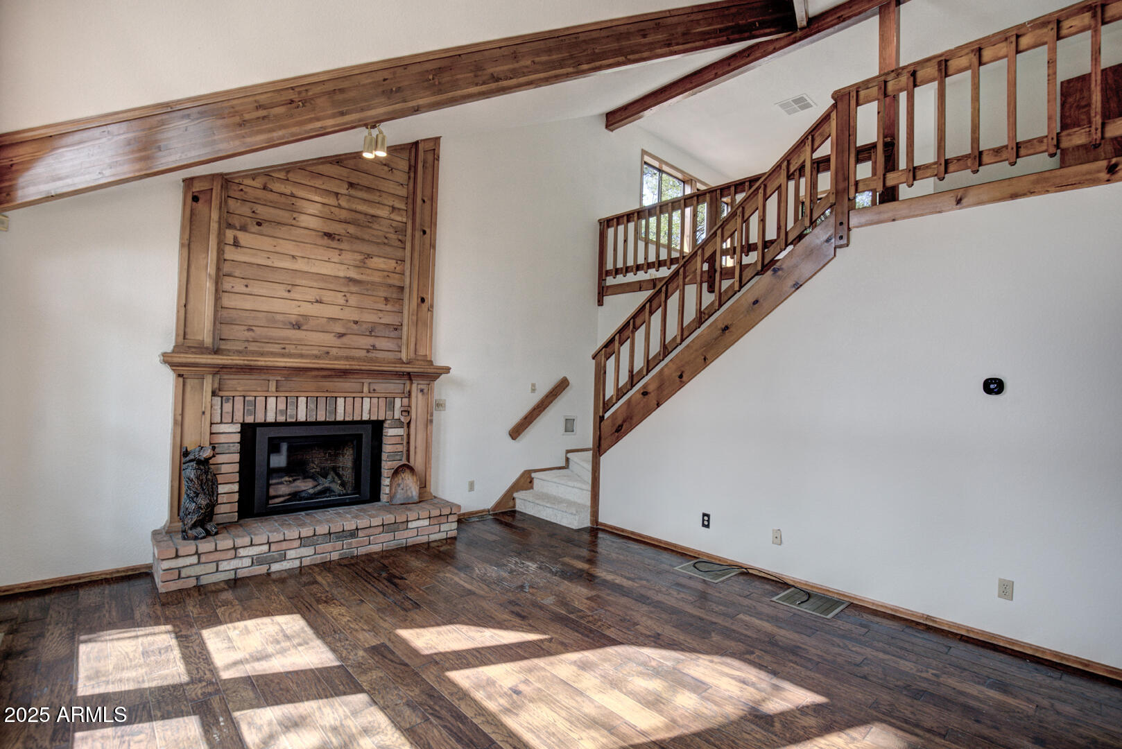 5115 Monte Vista Pine, AZ 85544 - Photo 11 of 35 a view of an empty room with wooden floor a fireplace and a window