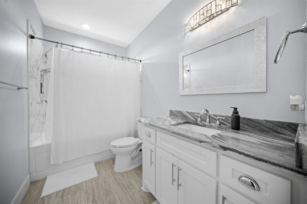 10405 Singleton Road Midlothian, TX 76065 - Photo 23 of 39 Bathroom featuring vanity, shower / bath combo with shower curtain, and light wood-style floors