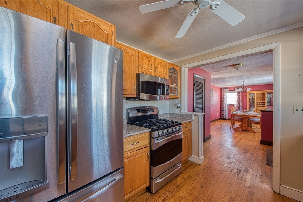 12 Brewster Road Randolph, MA 02368 - Photo 10 of 27 a kitchen with stainless steel appliances a stove a refrigerator and a fireplace