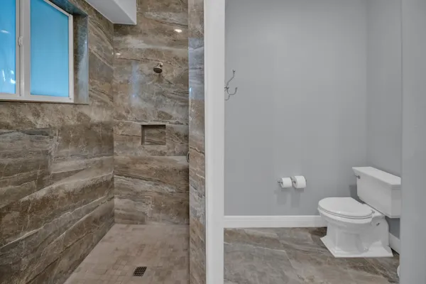 a white toilet sitting next to a bathroom sink