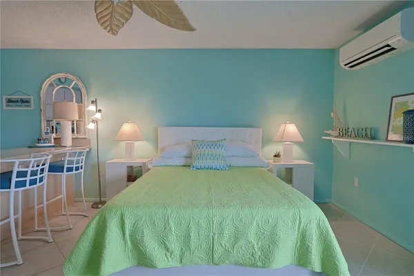 a bed sitting in a bedroom next to a lamp